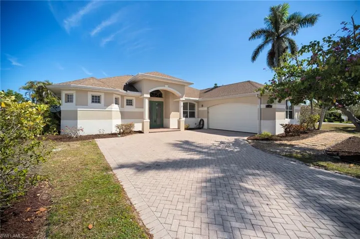 Mediterranean / spanish house with decorative driveway, an attached garage, and stucco siding