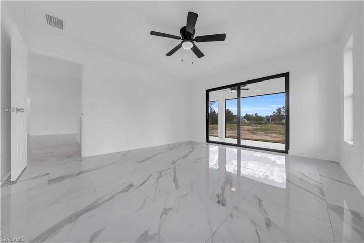 Spare room featuring light marble finish floors and ceiling fan
