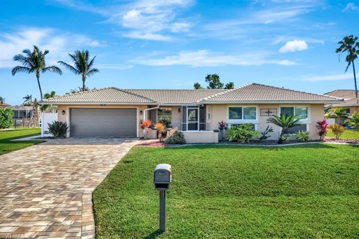 Single story home featuring a garage and a front yard