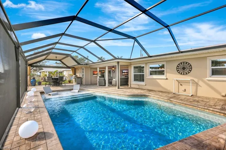 View of swimming pool with a patio and glass enclosure