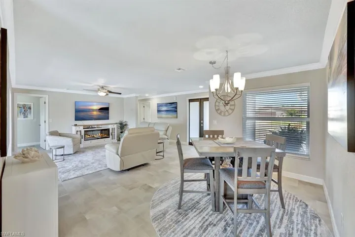 Dining space featuring crown molding and ceiling fan with notable chandelier