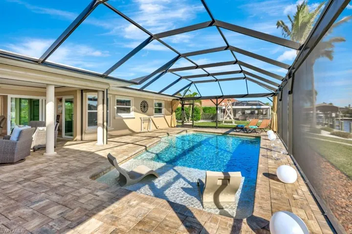 View of salt pool sun shelf featuring a lanai with ew pavers