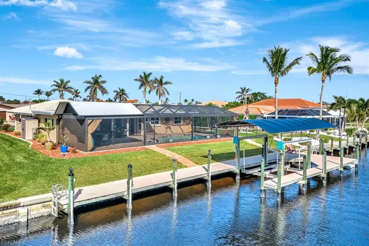 View of dock with a wrap around dock, a yard, a lanai, and a swimming pool