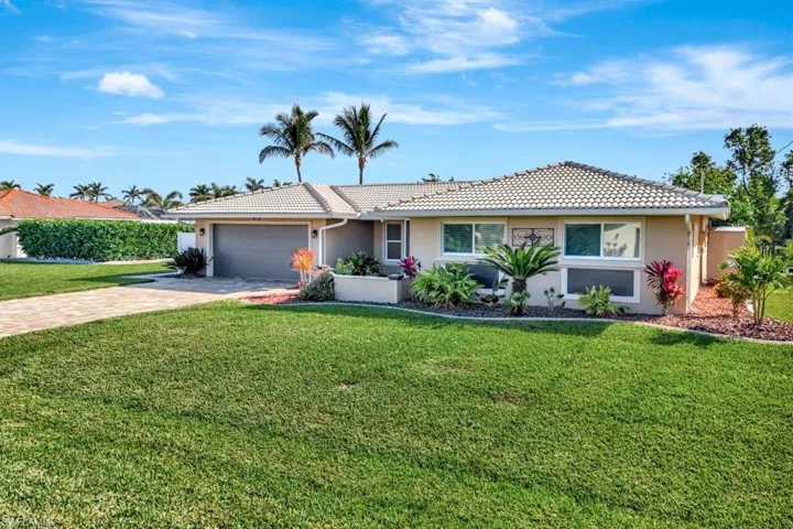 Ranch-style house featuring a garage and a front lawn