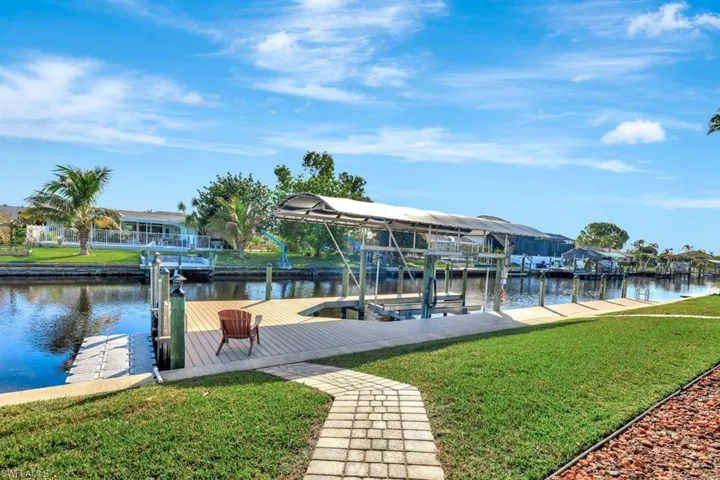 View of dock with a yard and a water view walkway