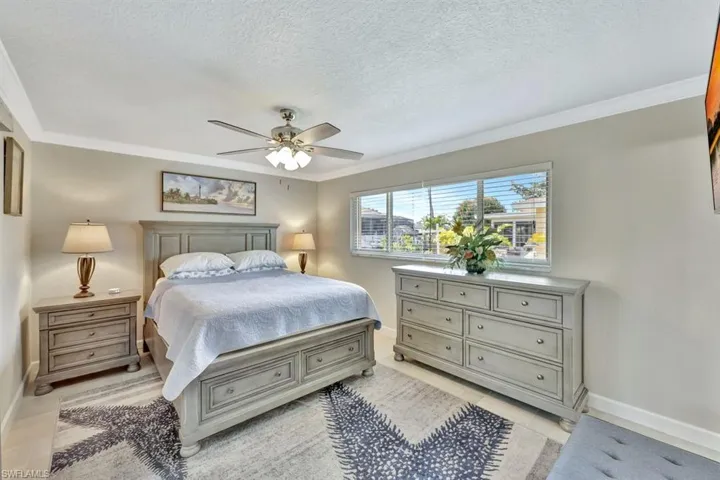 Bedroom featuring crown molding, a textured ceiling, and ceiling fan