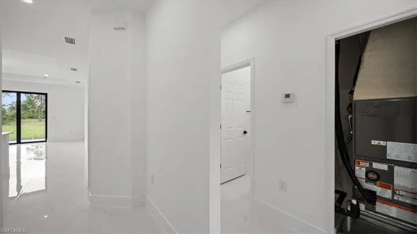 Hallway with marble finish flooring, heating unit, and recessed lighting
