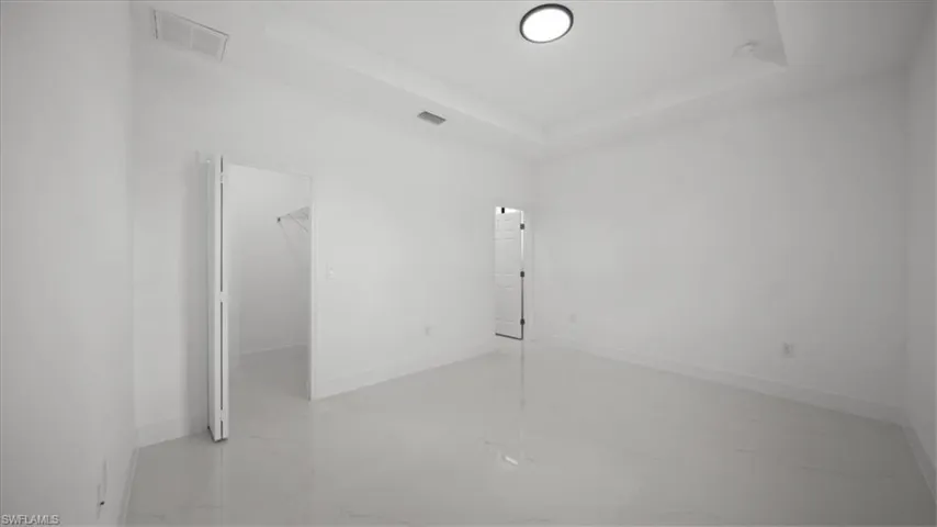 Spare room with marble look tiles and a tray ceiling