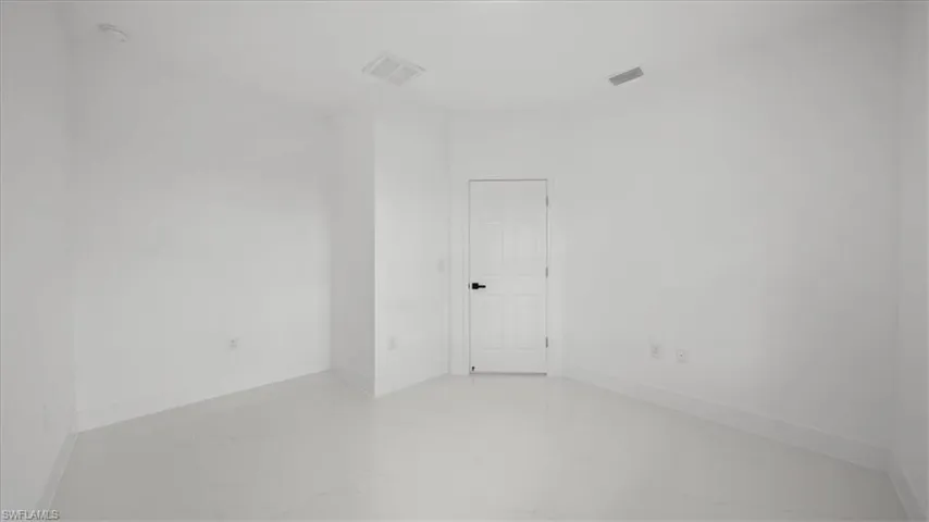Spare room featuring light marble finish floors
