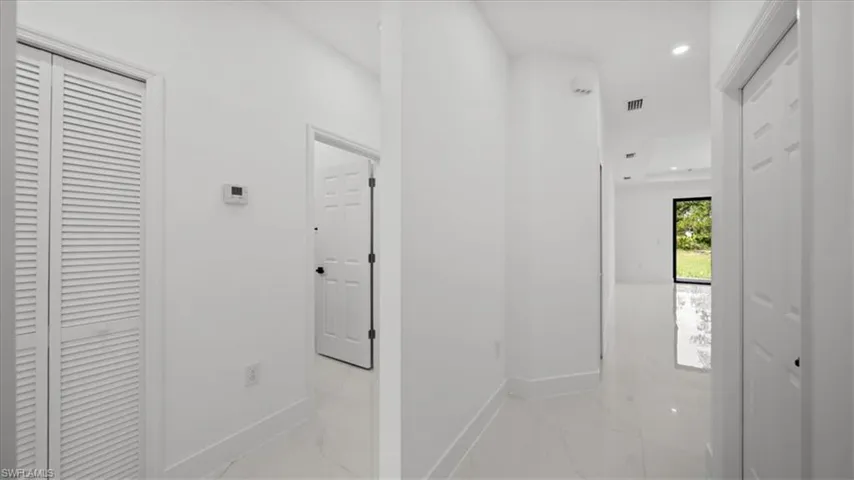 Hallway featuring marble finish floors and recessed lighting
