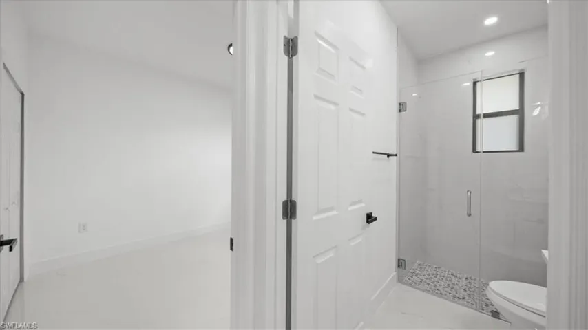 Full bathroom featuring marble look tile flooring, a marble finish shower, and recessed lighting