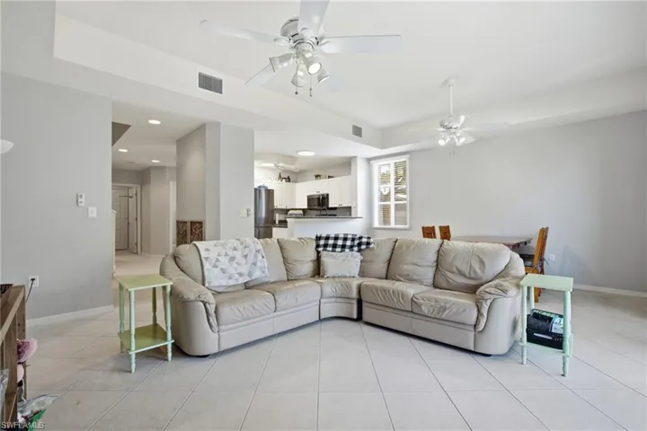Living room featuring light tile patterned floors, a ceiling fan, and recessed lighting