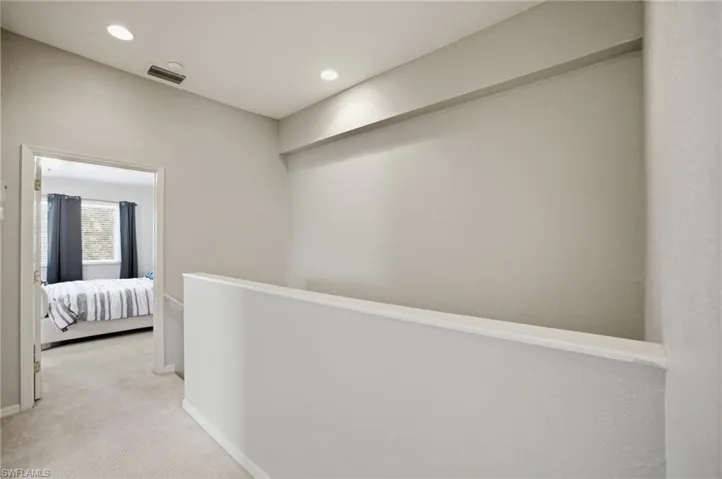 Corridor featuring light colored carpet and recessed lighting