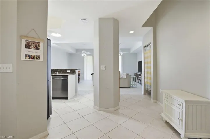 Hall with light tile patterned floors and recessed lighting