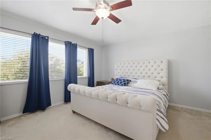 Carpeted bedroom featuring baseboards and a ceiling fan