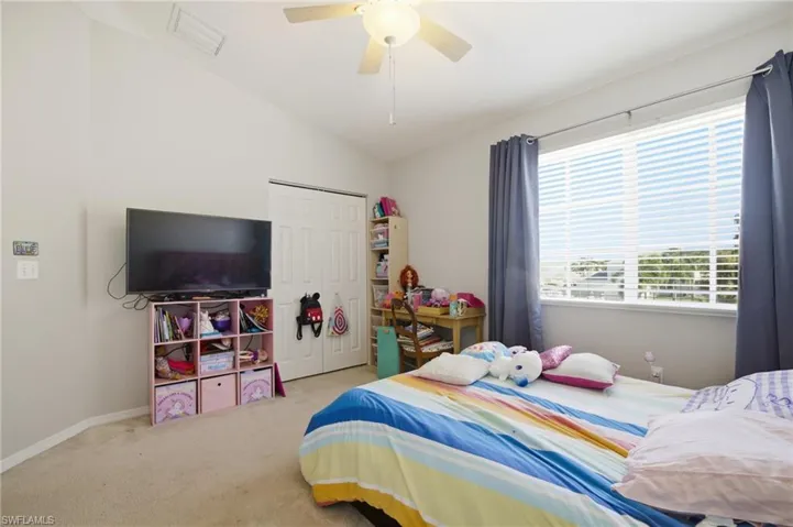 Bedroom featuring lofted ceiling, carpet flooring, a closet, and ceiling fan