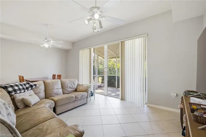 Living area featuring light tile patterned floors and ceiling fan