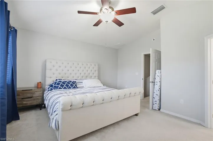 Bedroom with carpet floors, vaulted ceiling, and a ceiling fan