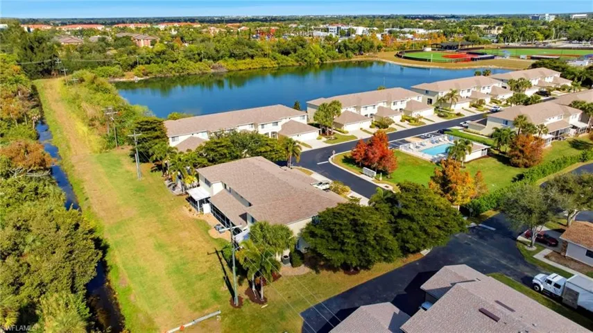 Aerial perspective of suburban area with a nearby body of water and a tree filled landscape