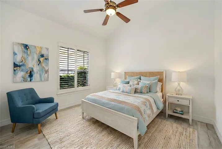 Bedroom with light wood-type flooring, vaulted ceiling, and ceiling fan