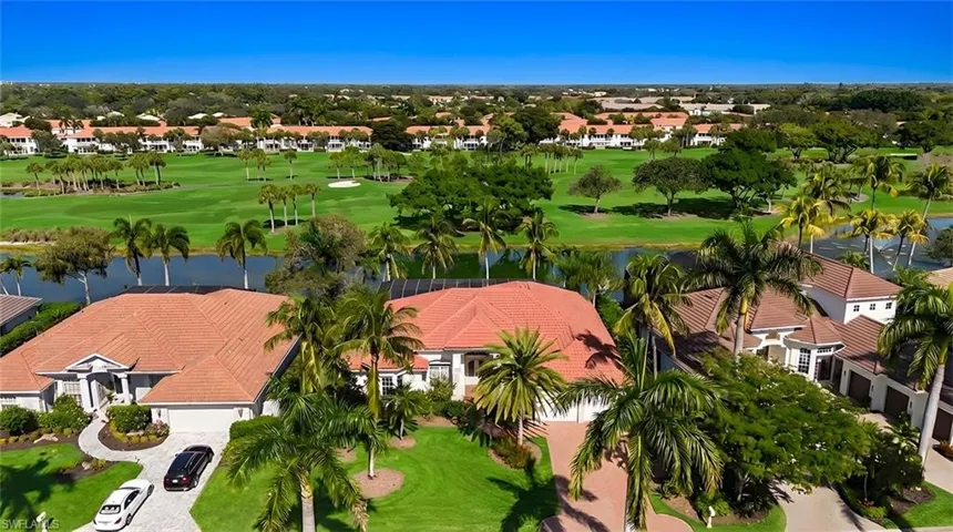 Aerial view of residential area featuring a local golf course and a nearby body of water