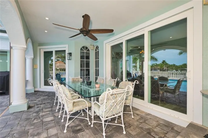 View of patio with outdoor dining area, ceiling fan, and a grill