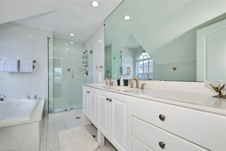 Bathroom with double vanity, a garden tub, a stall shower, light tile patterned floors, and recessed lighting