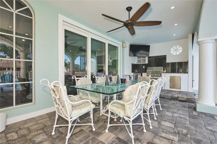 Dining room featuring ornate columns, a ceiling fan, dark stone finish flooring, and recessed lighting