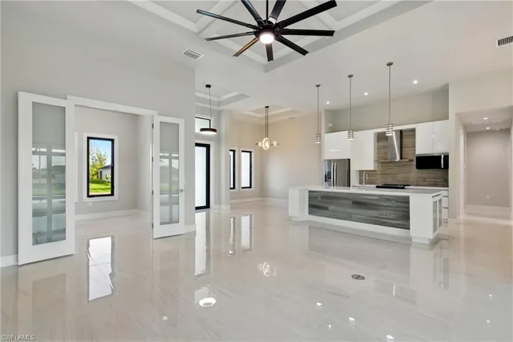 View of living, kitchen, doors leading to 4th bedroom/den with closet