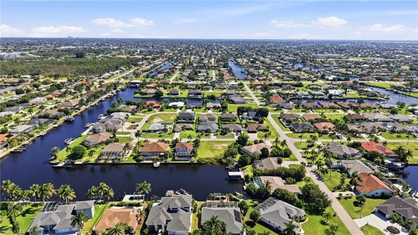 Aerial perspective of a waterfront residential neighborhood featuring an interconnected canal system and established landscaping