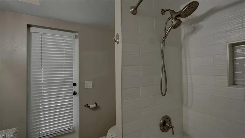 Shower featuring a dual shower head system with a handheld sprayer and brushed nickel fixtures