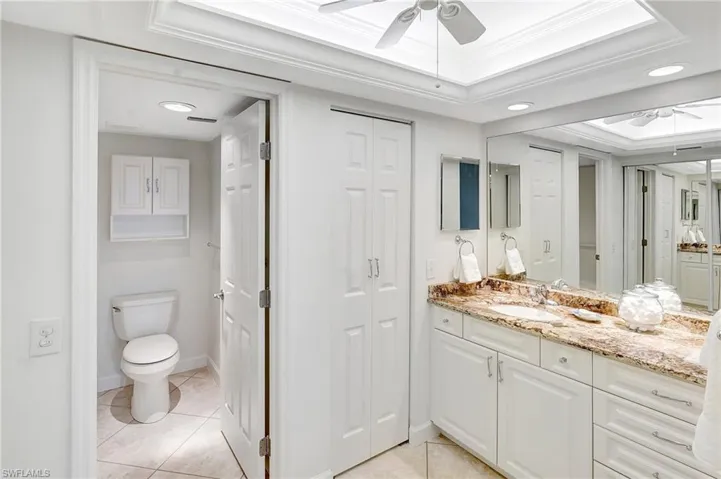 Bathroom with a closet, ceiling fan, vanity, crown molding, and recessed lighting
