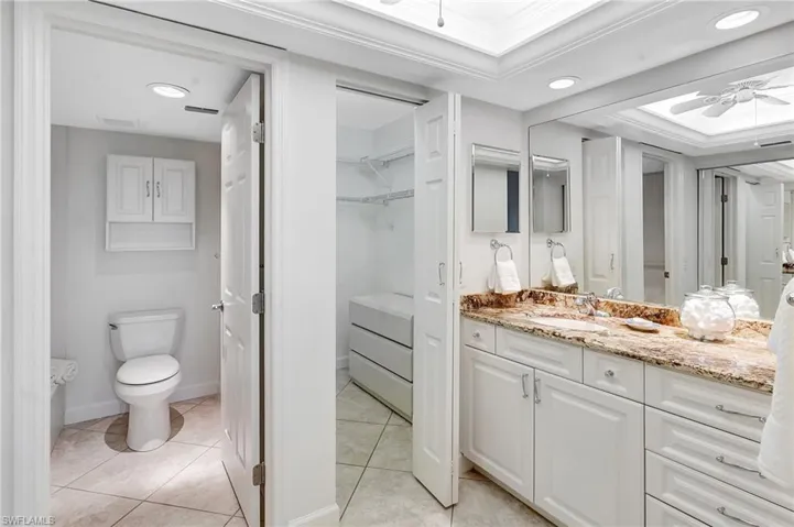 Full bath with a ceiling fan, vanity, light tile patterned floors, a walk in closet, and recessed lighting