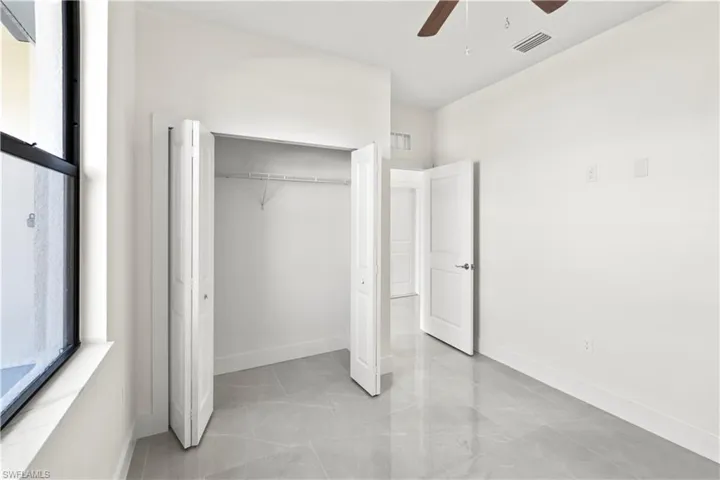 Unfurnished bedroom featuring a ceiling fan and a closet