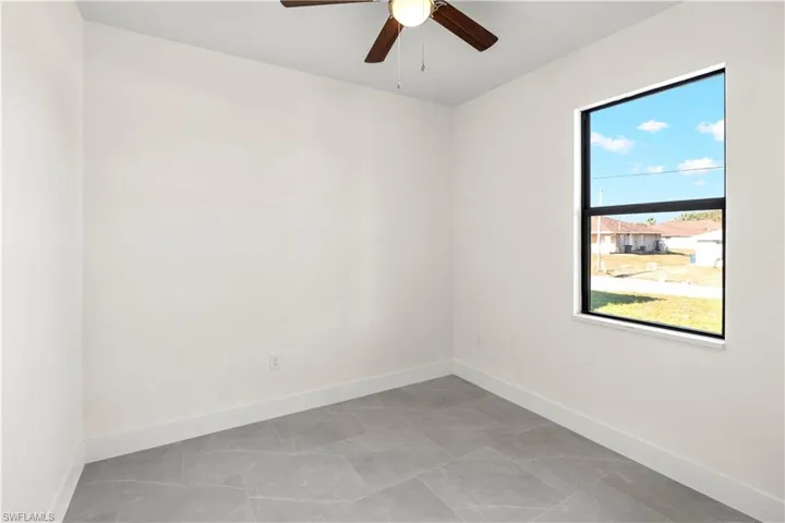 Empty room featuring baseboards and a ceiling fan