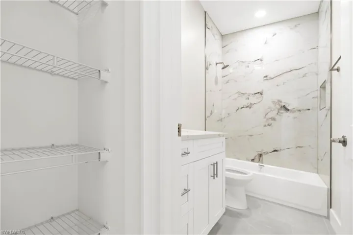 Full bath with vanity, bathtub / shower combination, recessed lighting, and light marble finish floors