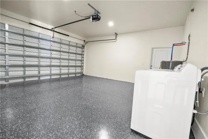 Garage featuring independent washer and dryer and a garage door opener