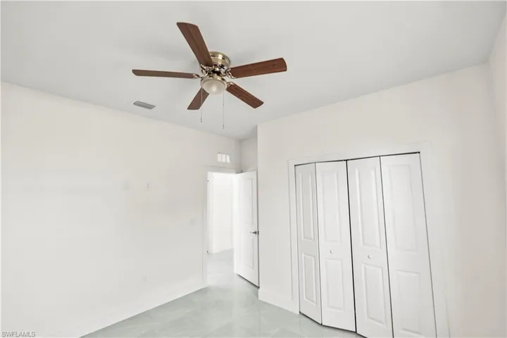 Unfurnished bedroom featuring a ceiling fan and a closet