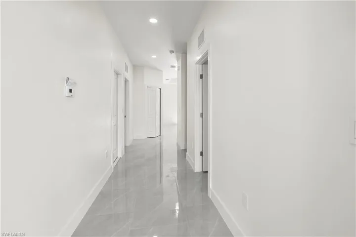 Corridor with baseboards and recessed lighting