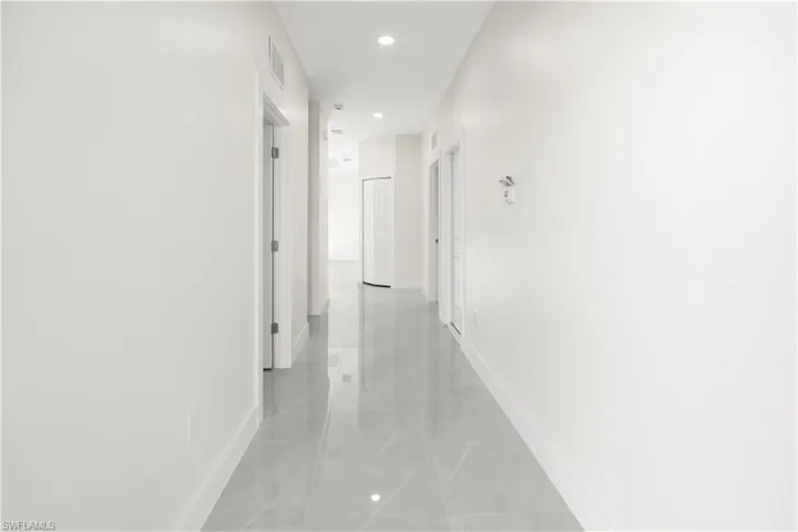 Hall with baseboards and recessed lighting