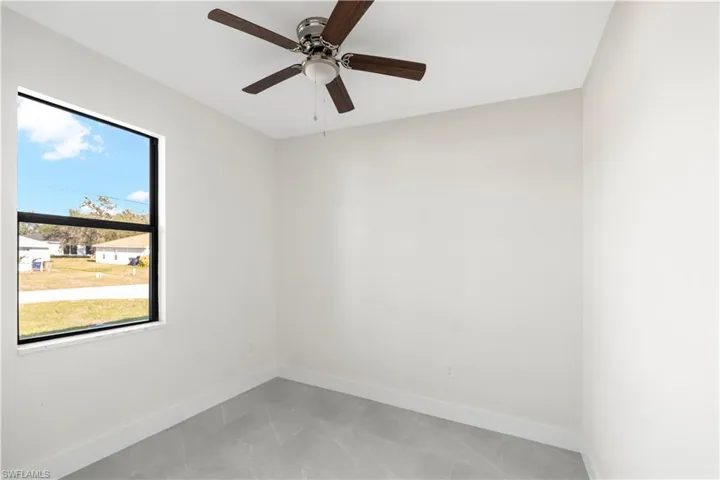 Unfurnished room with baseboards and a ceiling fan