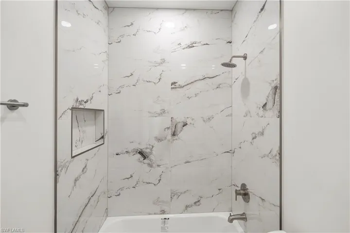 Full bathroom featuring washtub / shower combination and toilet