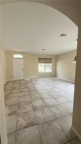 Spare room with arched walkways and light tile patterned flooring