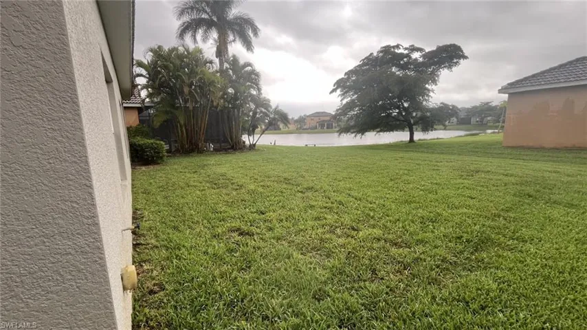 View of green lawn featuring a water view