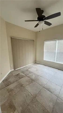 Spare room featuring baseboards and ceiling fan