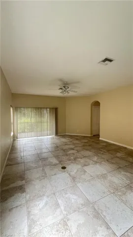 Spare room with arched walkways and ceiling fan