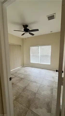 Spare room featuring a ceiling fan and baseboards