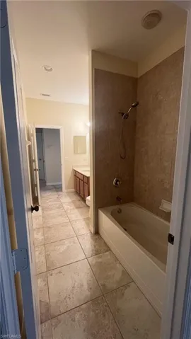 Bathroom featuring vanity, tub / shower combination, and light tile patterned floors