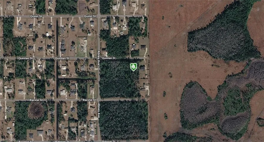 Satellite Imagery. Displaying a residential area and undeveloped land, with a property marked by an icon