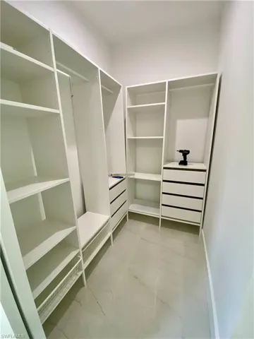Walk in closet with light tile patterned floors
